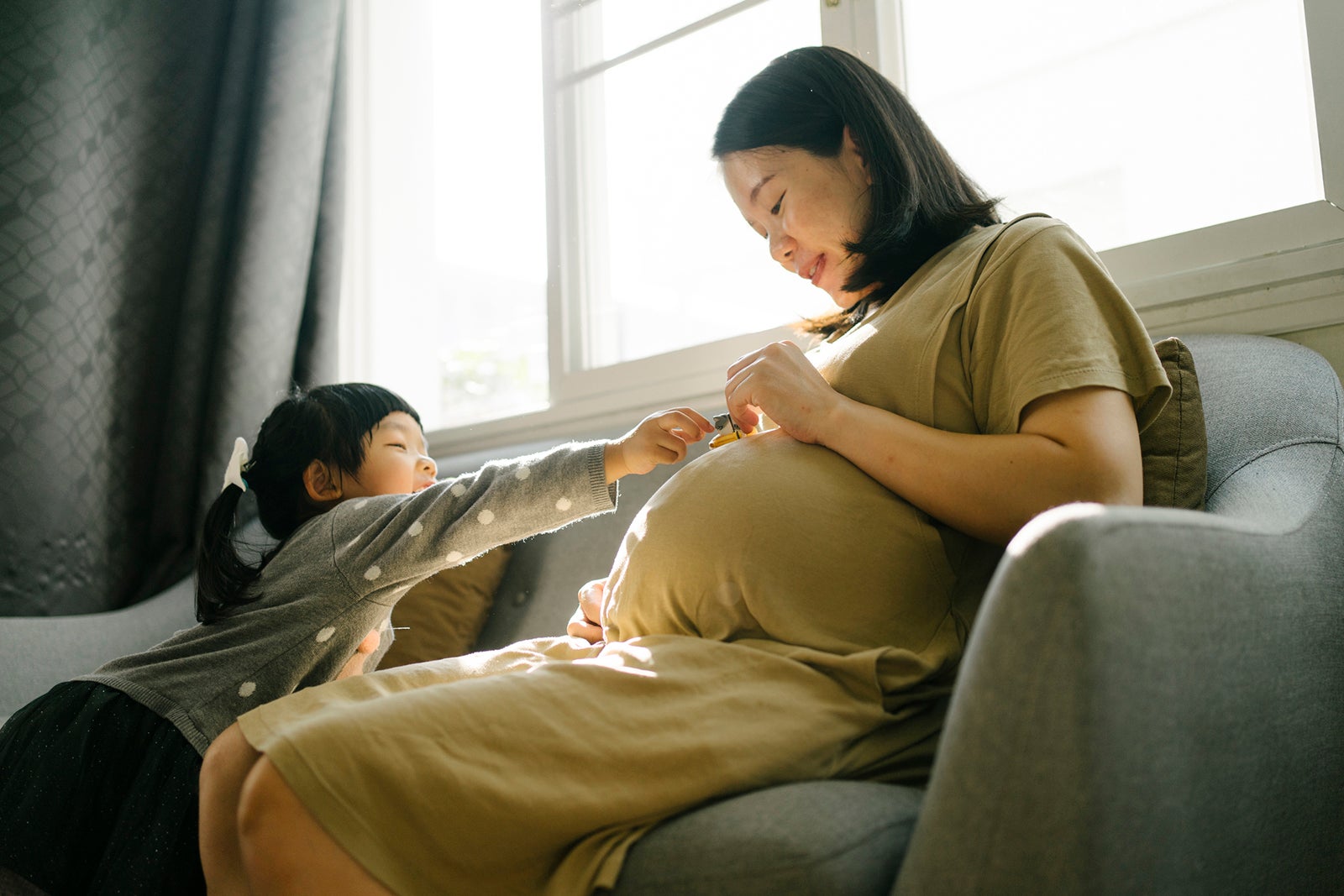 Beautiful moment Asian mother pregnant second baby and spending time to playing with first daughter at home