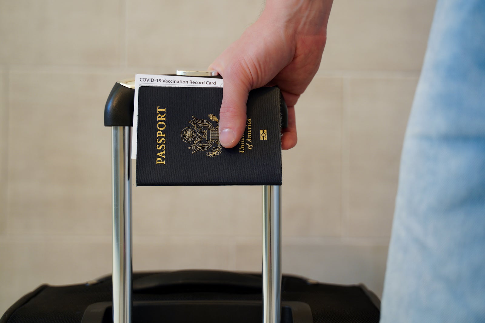 a traveler carries a suitcase with a U.S. passport