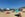 Sunbathers and colorful umbrellas on San Giuliano Beach, Trapani, Italy.