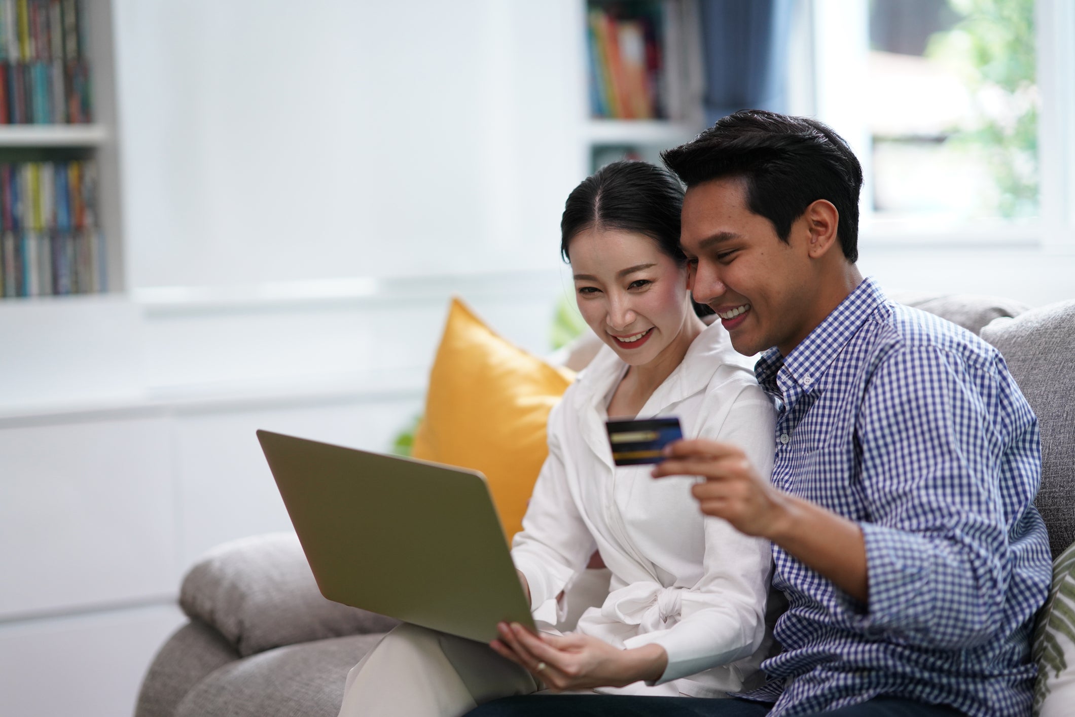 Young married couples cheerful using laptop and credit card to shopping online