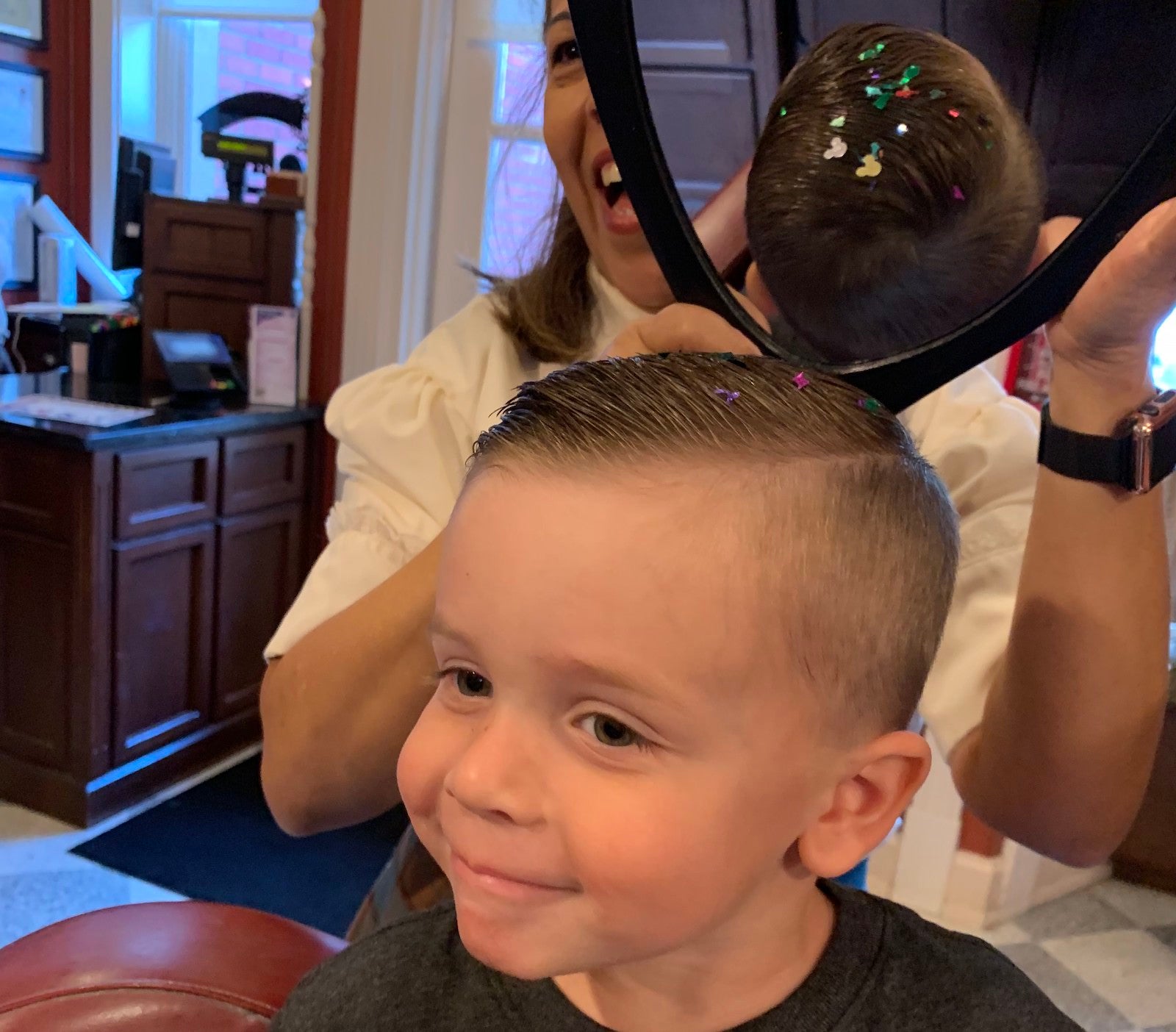 Child looking at haircut in the mirror