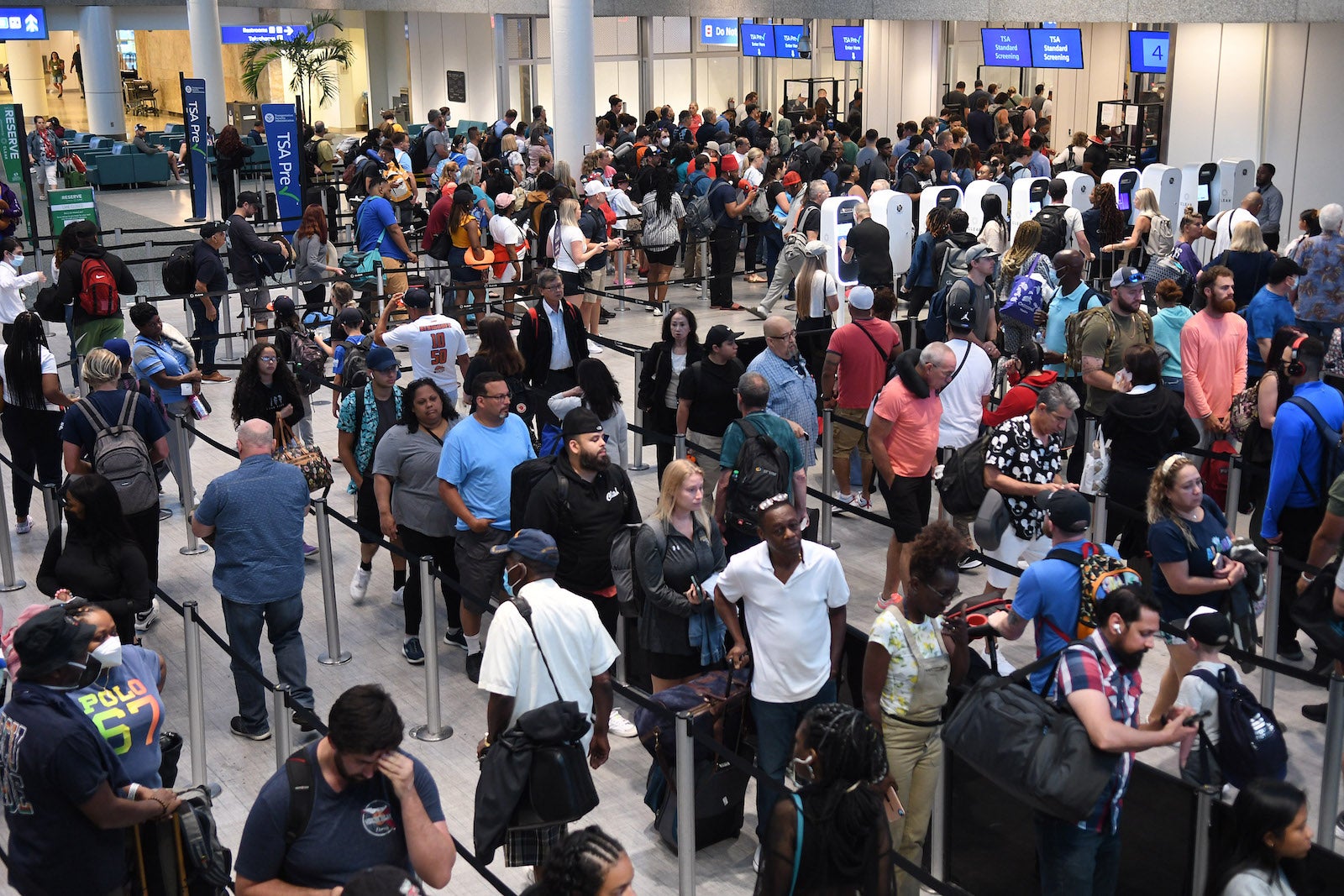 Travelers make their way through a TSA screening line at