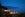 view of glowing glass hotel with mountains in the distance