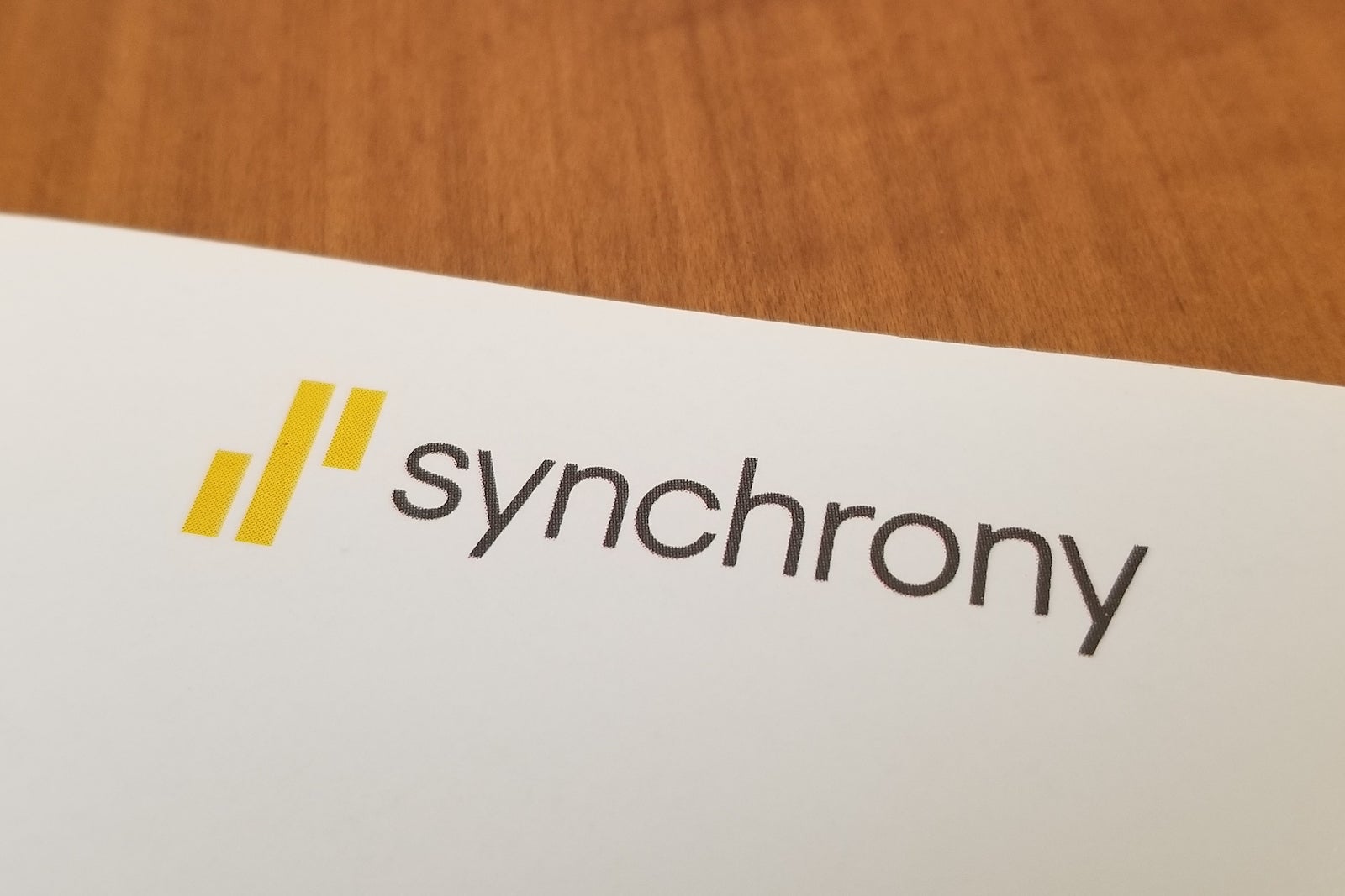Close-up of logo for Synchrony Bank on a paper on a light wooden surface, July 10, 2019. (Photo by Smith Collection/Gado/Getty Images)