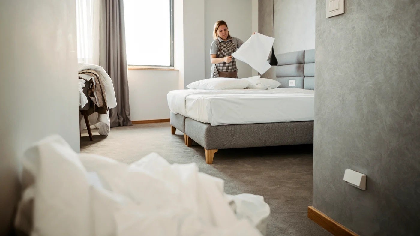 Housekeeping staff cleans hotel room