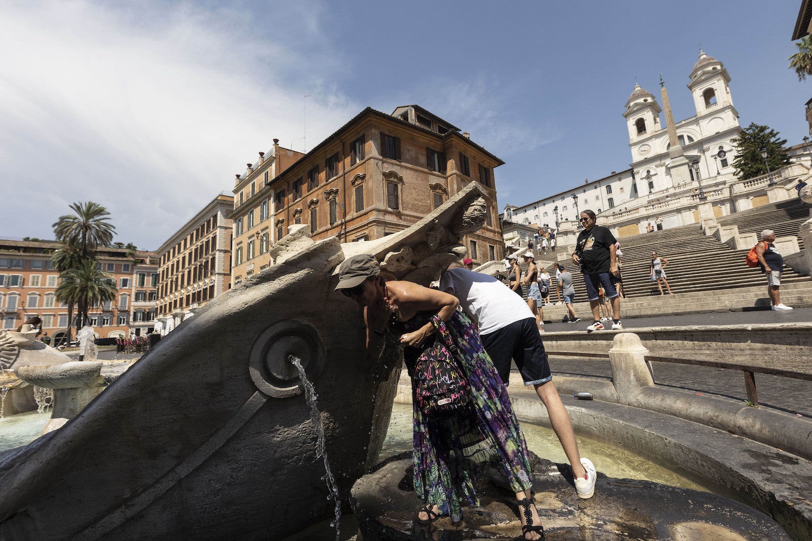 Tourists in Italy refresh themselves from the heat