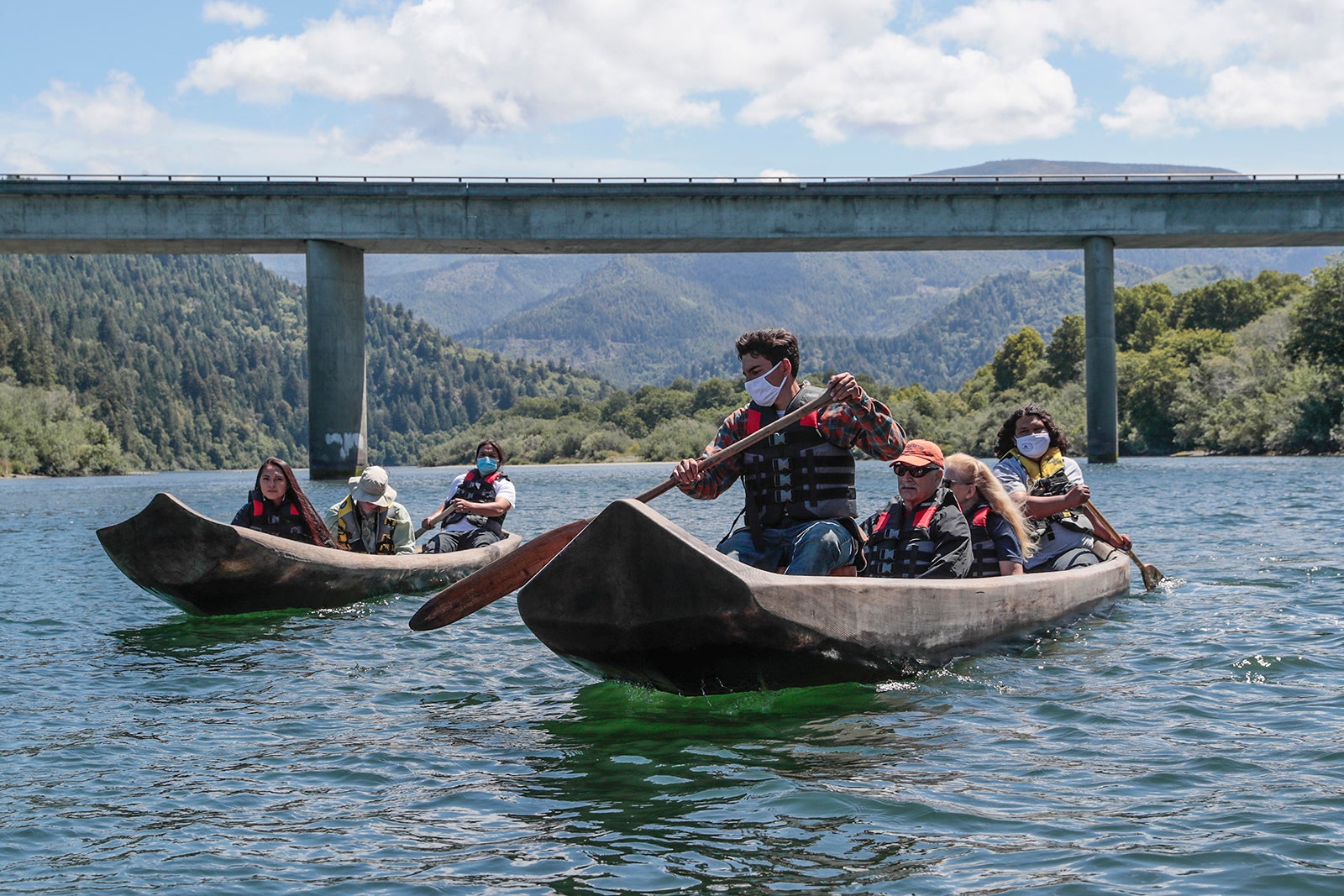 Yurok guides Zechariah Gabel, front, Sammy Gensaw, right and Jon-Luke Gensaw, left,  paddle tourists along the Klamath River in traditional canoes hand crafted from Redwood trees.