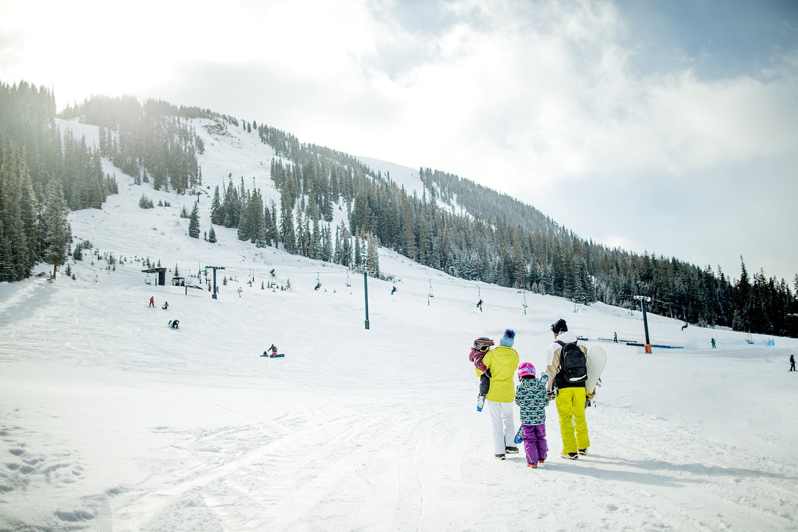 Mixed race family walking on snow at a ski resort in Colorado during the winter.