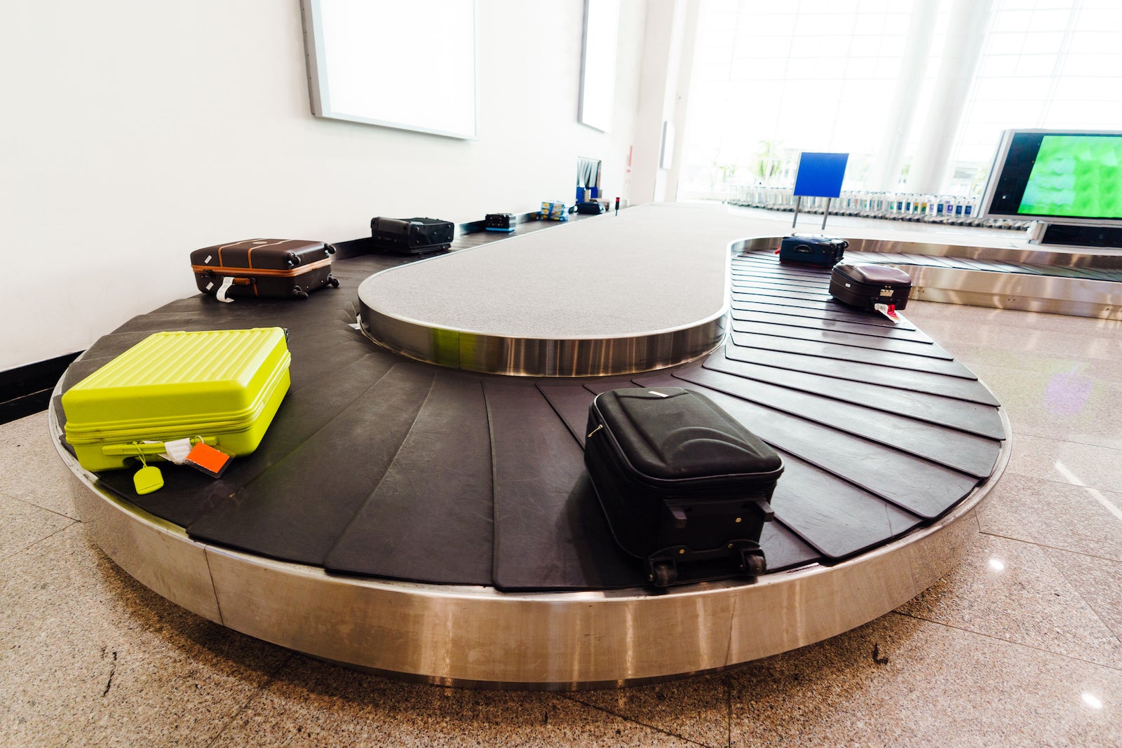 Suitcases on black conveyer belt with white background