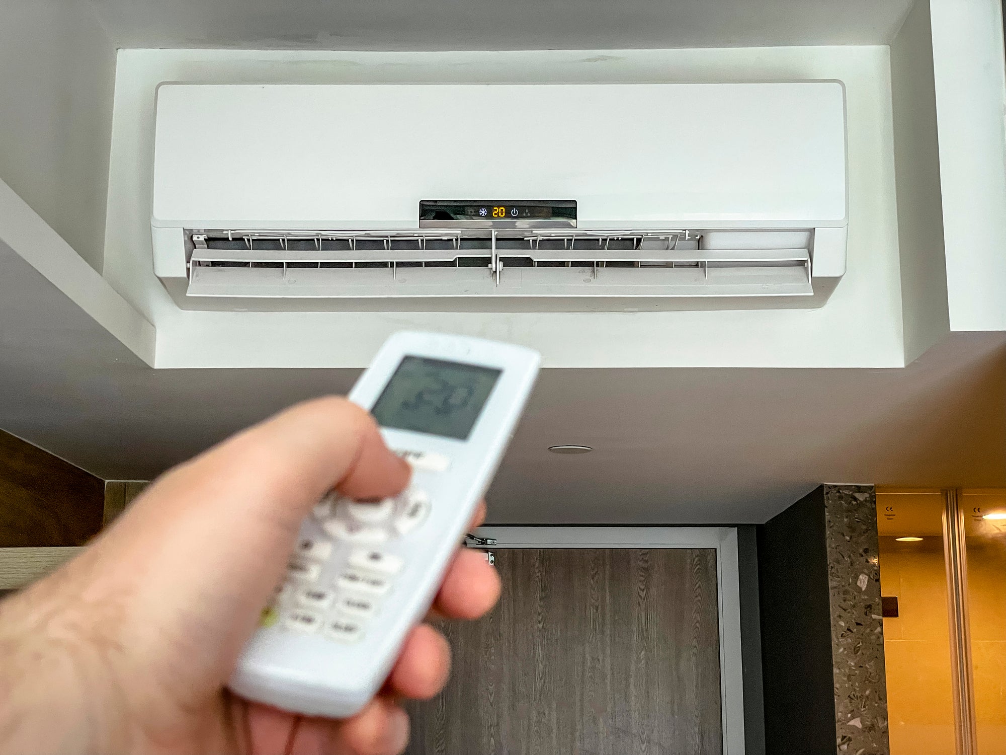 hotel guest uses remote control for thermostat