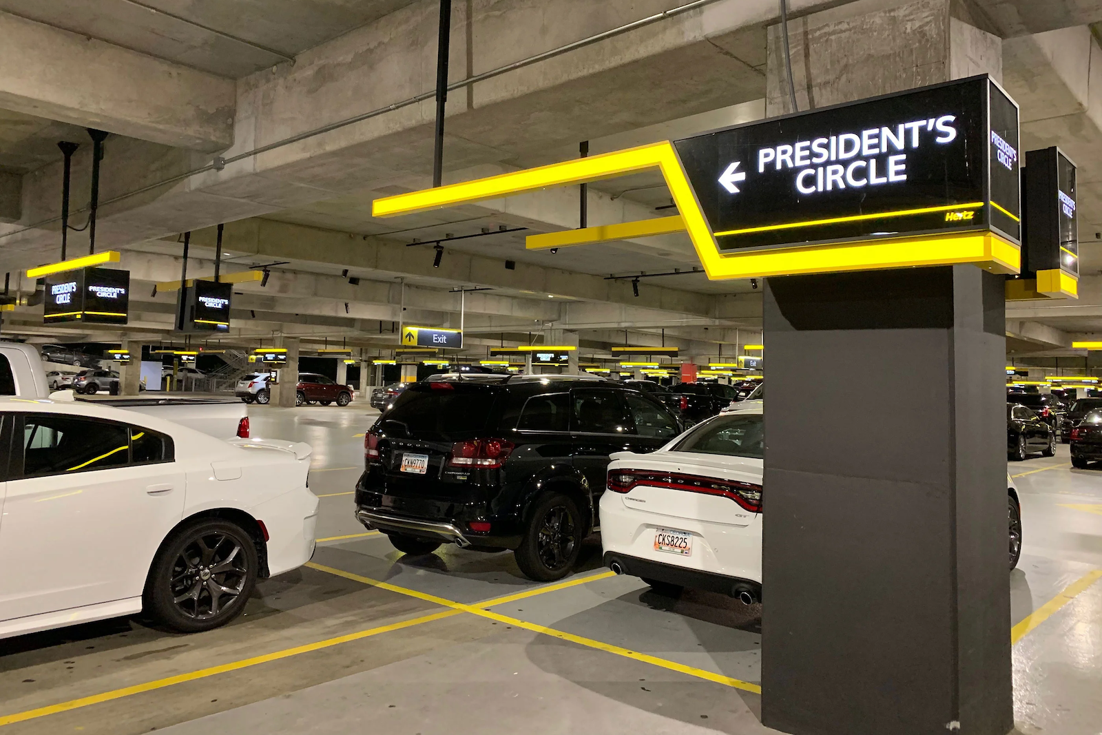 Rental cars next to a sign for Hertz President's Circle members