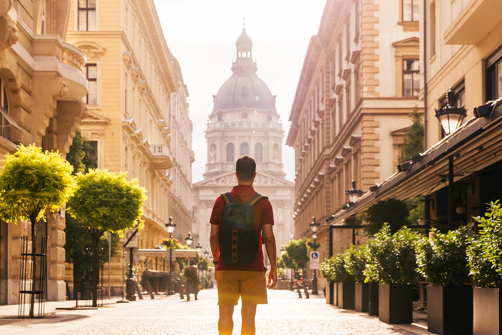 Rear view of a young man with backpack exploring the streets of Budapest, Hungary