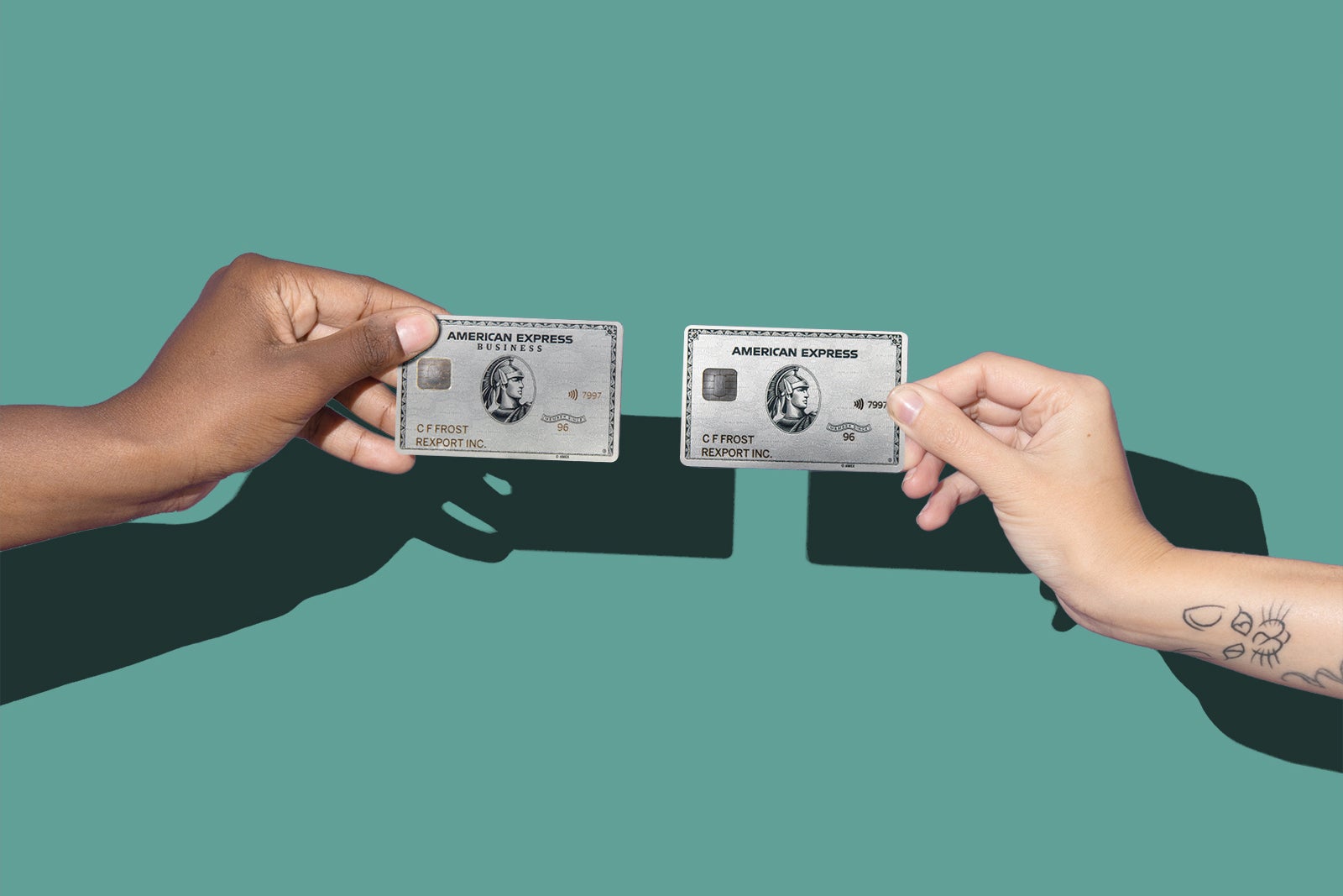 Two hands hold the Amex Platinum and Amex Business Platinum cards