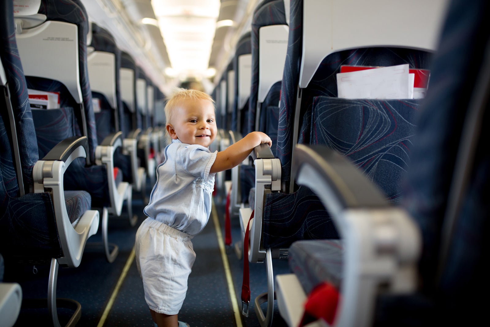 Flying With A Lap Infant Here S What You Need To Know The Points Guy   Baby Running Througth Airplane Isle Tatyana Tomsickova 