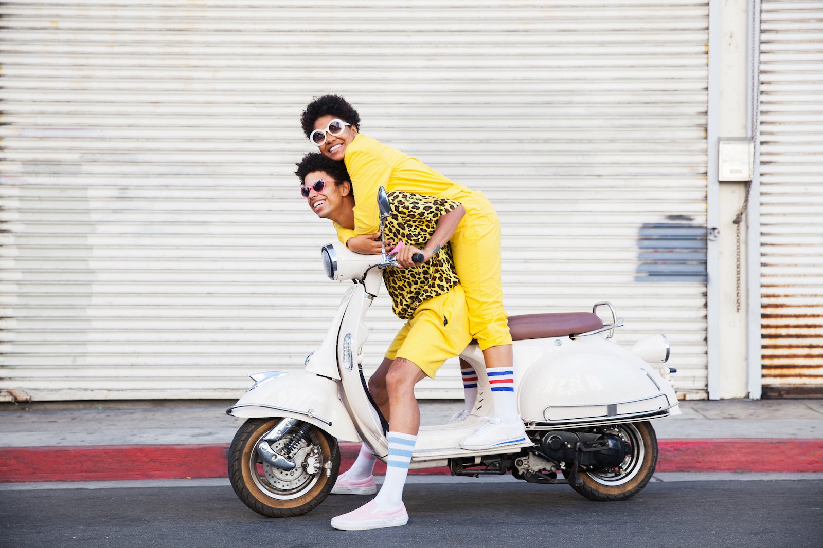 A hip young couple on a scooter