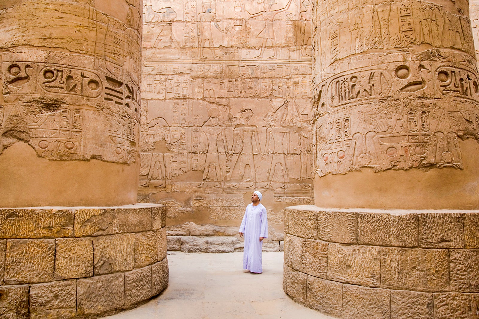 egyptian man standing in Karnak temple columns