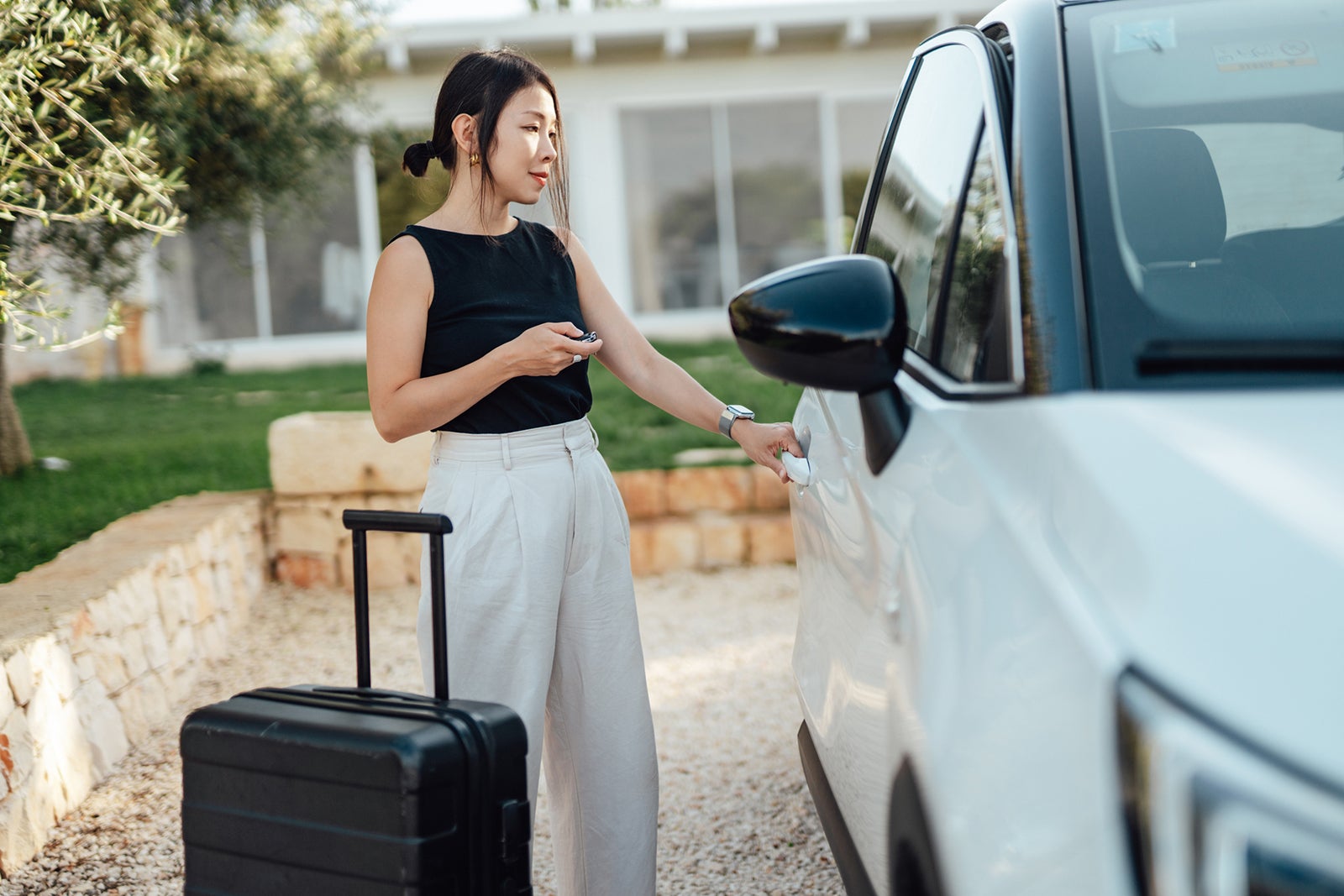 Young woman opening car door, ready for a road trip