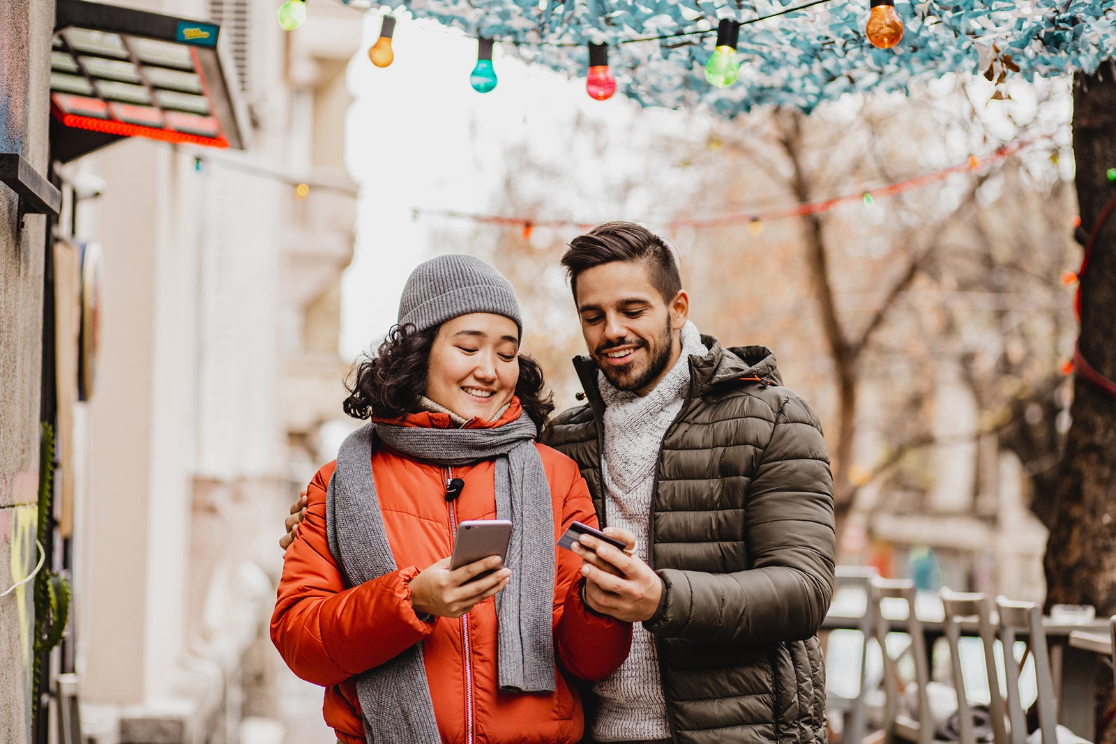 Young couple shopping online outdoors