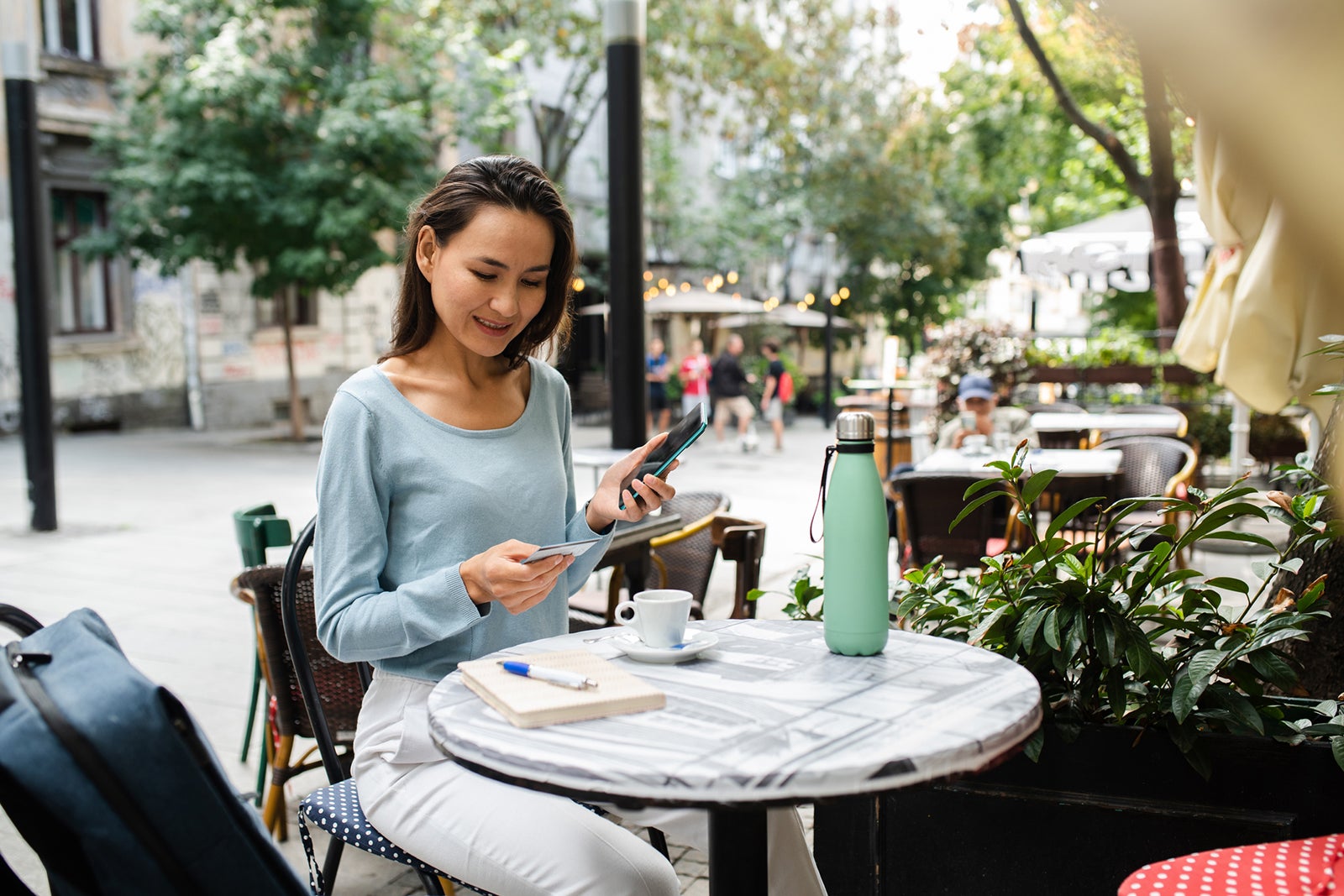 Happy Japanese woman enjoying coffee in the city and shopping online