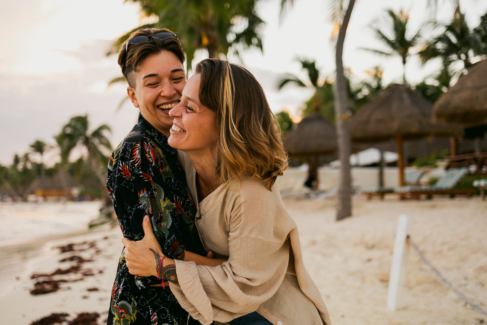 Same-sex couple standing and hugging on the beach
