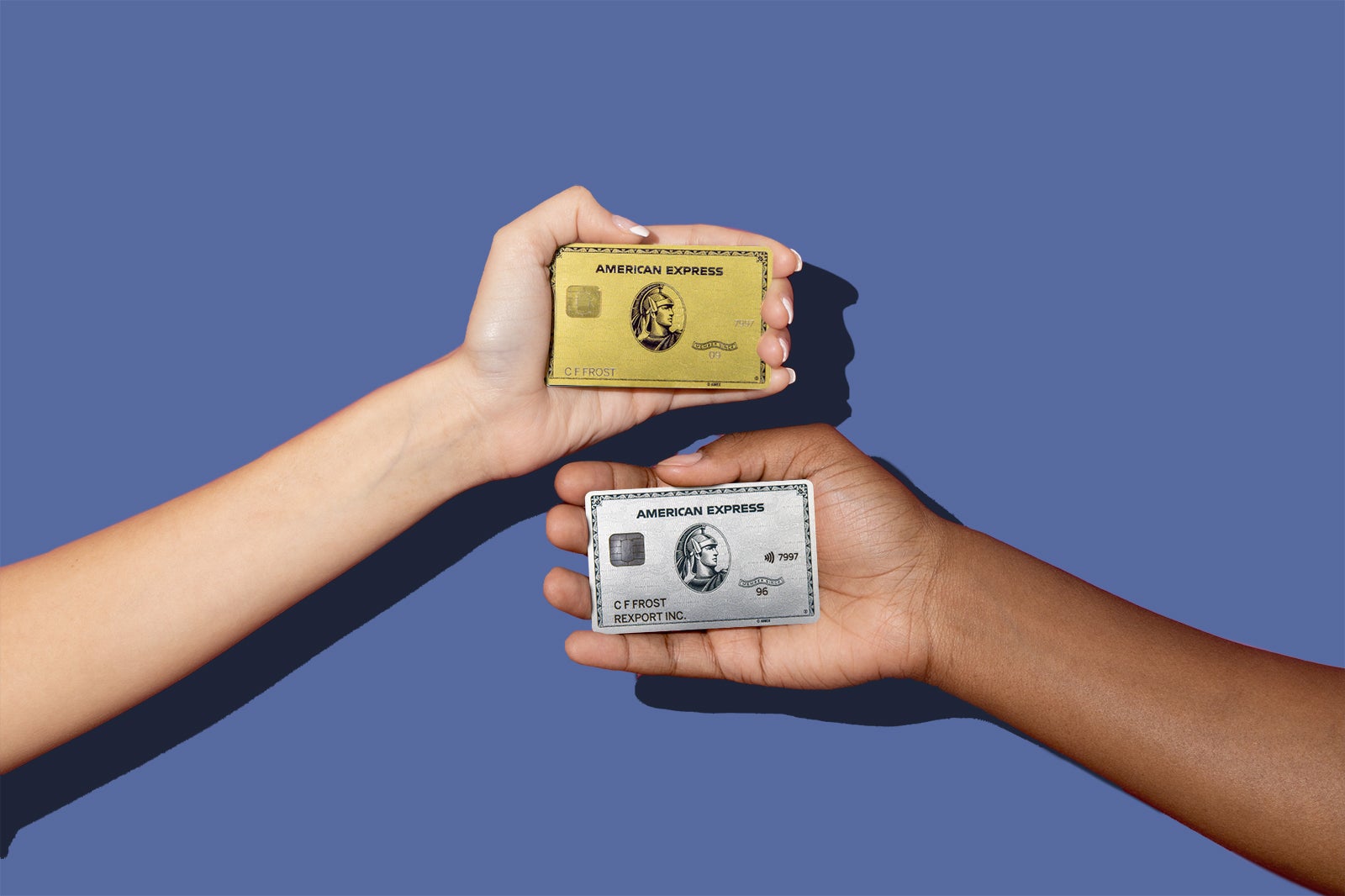 2 hands hold the Amex Gold and Amex Platinum cards