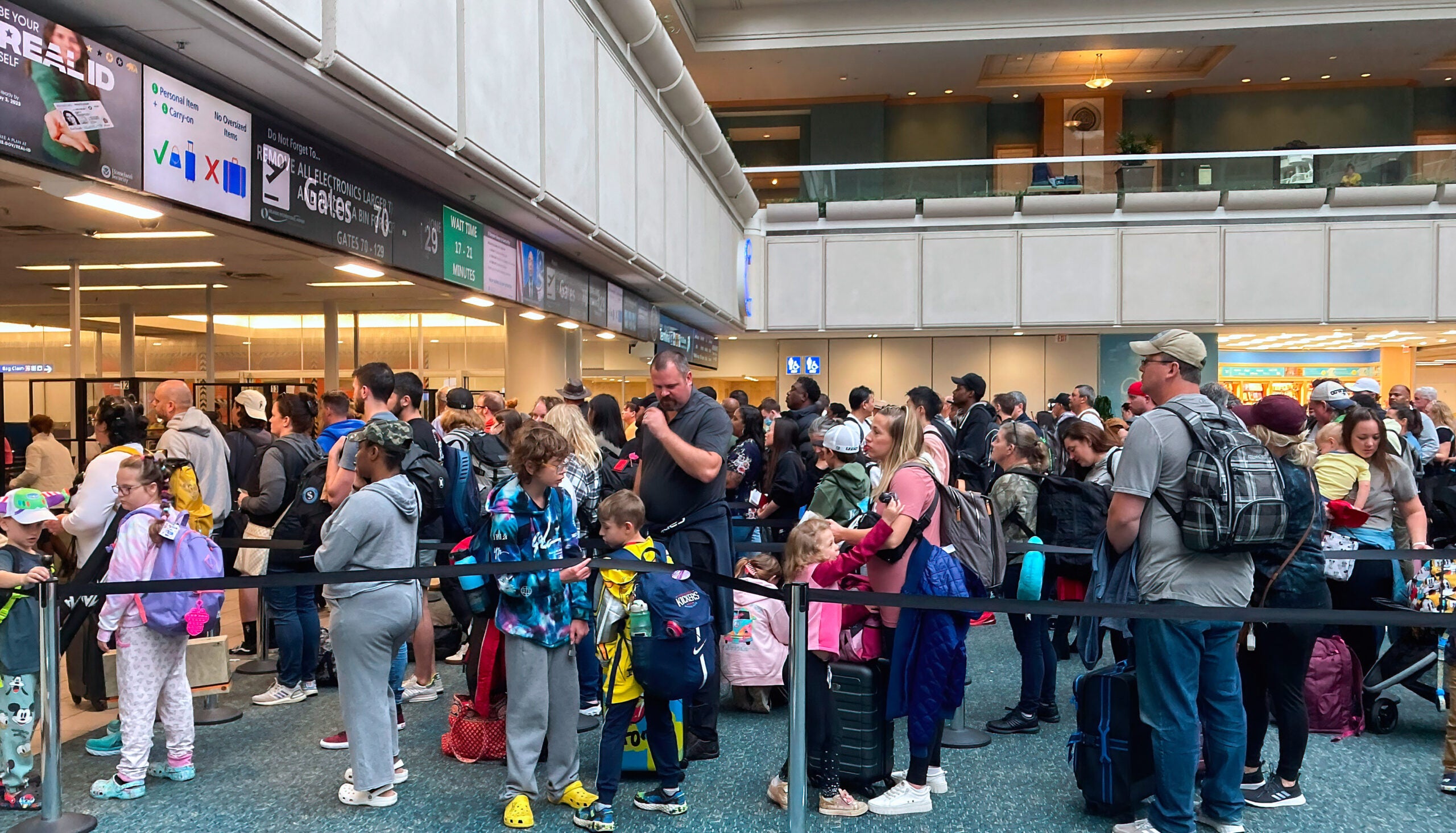 People wait in a TSA screening line at Orlando International