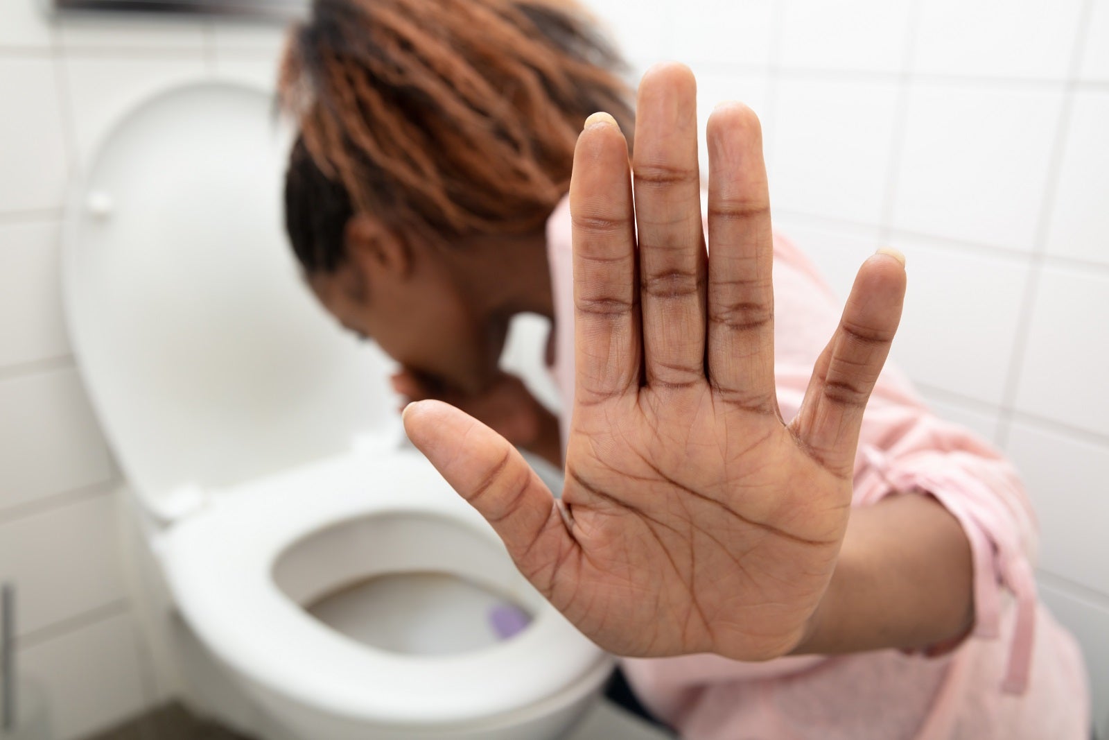 Close-up Of A Young Woman Vomiting In Toilet Bowl