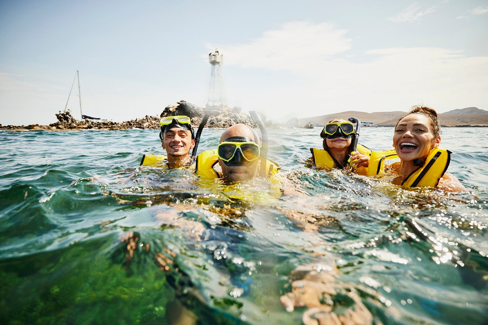 Medium shot of smiling family on snorkeling tour in tropical ocean