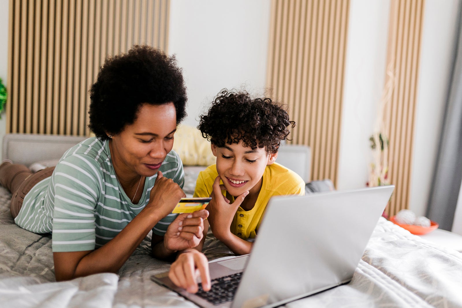 Son and mother online shopping at bedroom