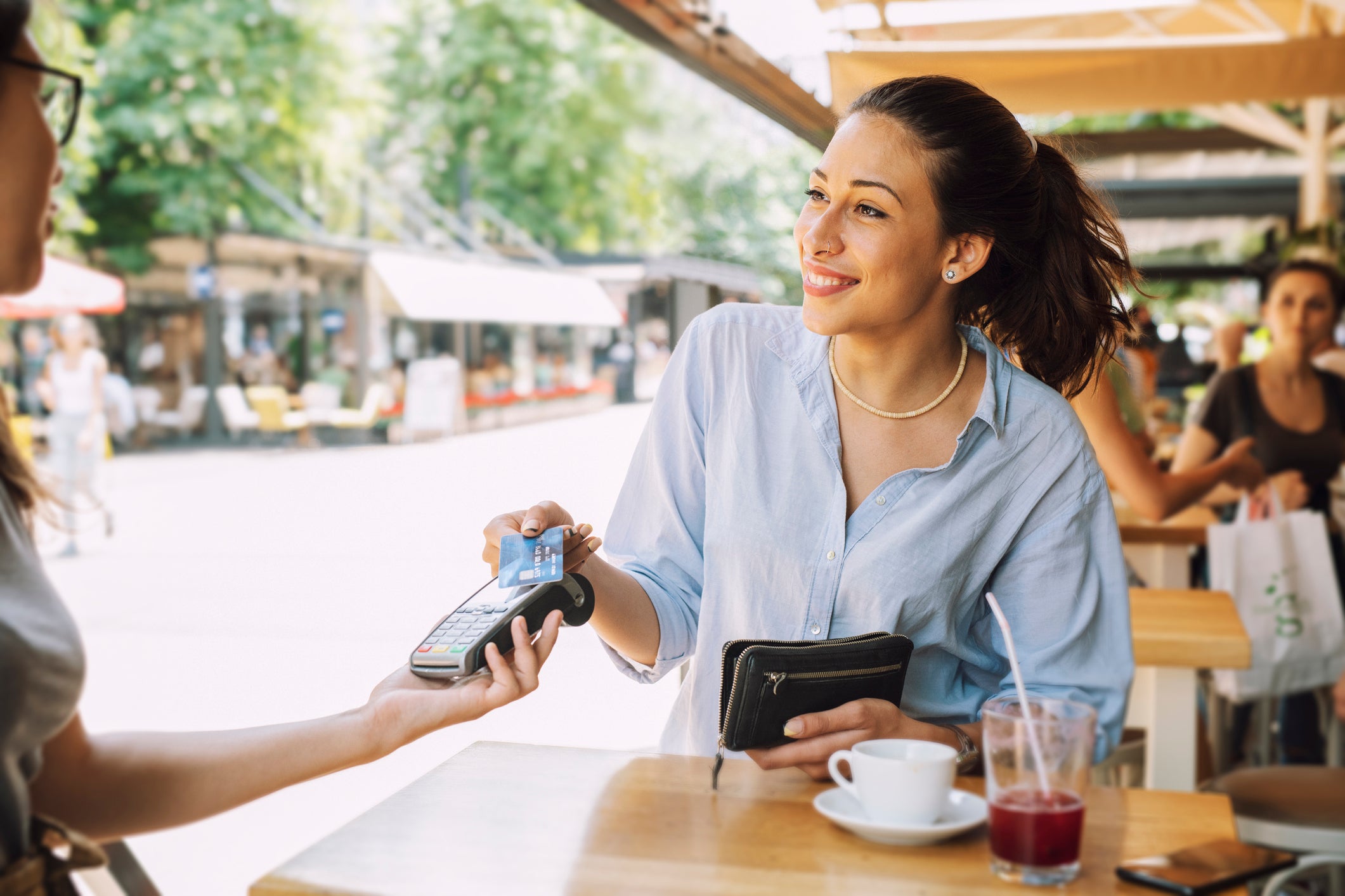 Smiling woman pays for cafe using credit card ArtistGNDphotography