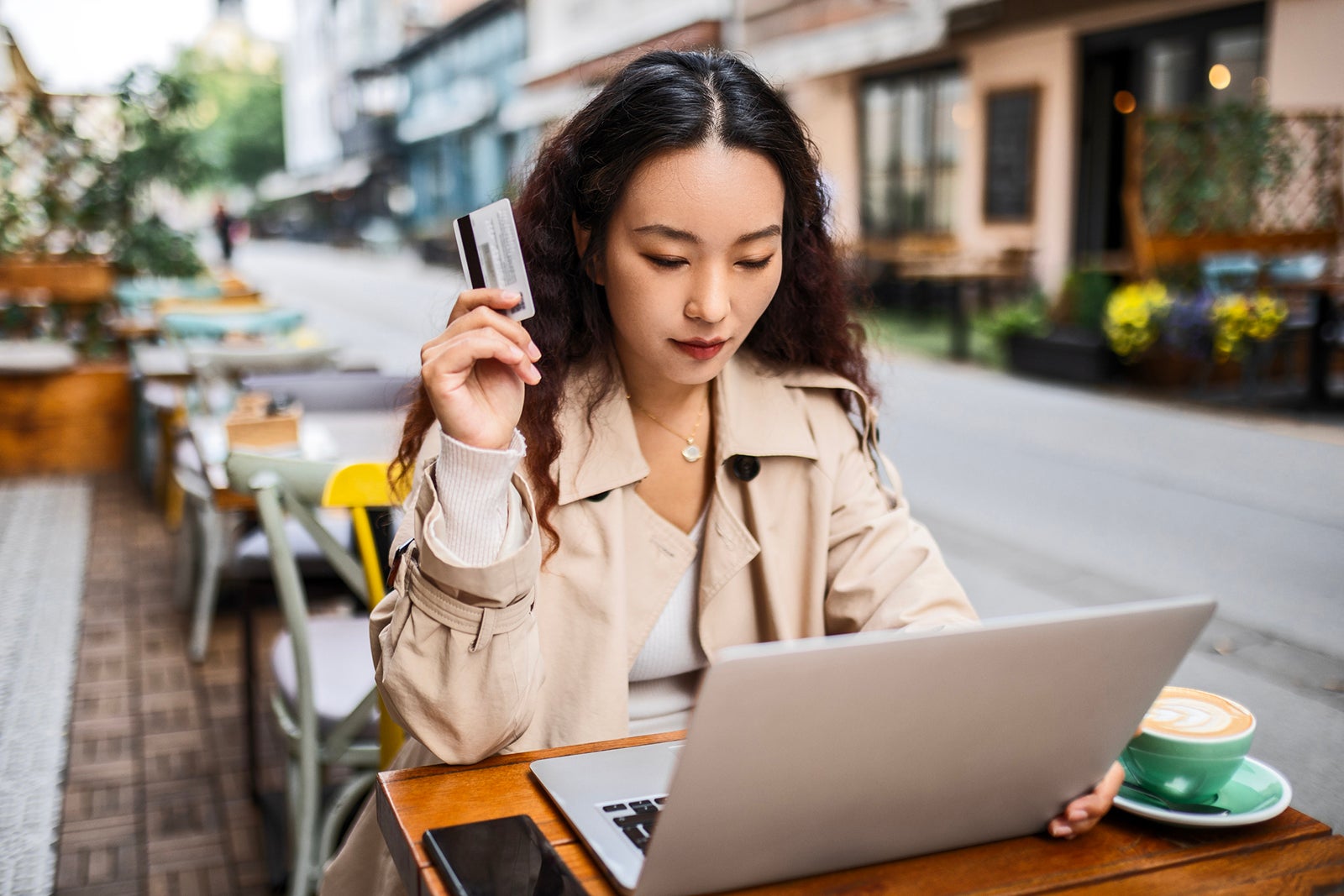 Young woman in cafe after shopping using credit card for online shopping