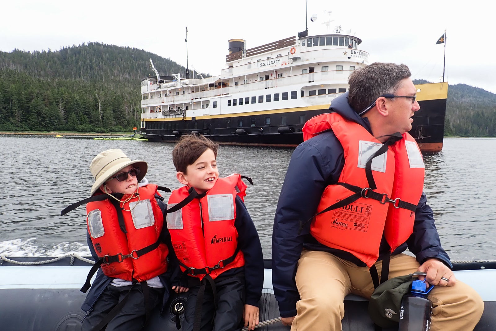 Family on a skiff tour next to The Legacy, Alaska. UNCRUISE