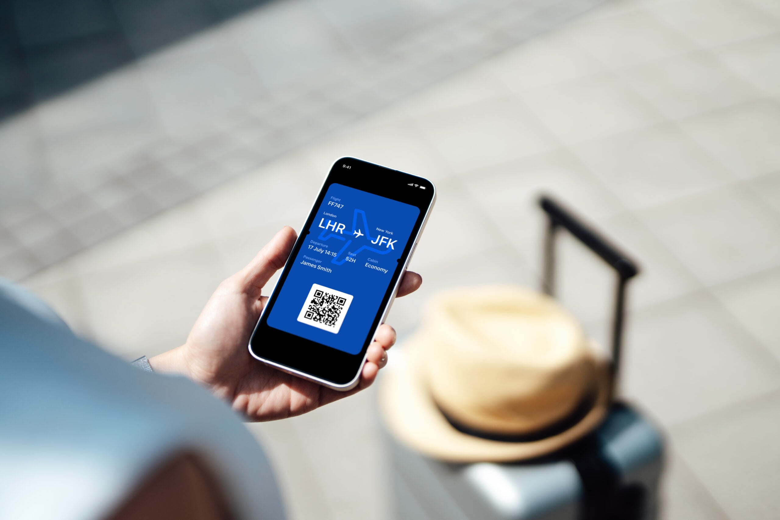 Close-up of female hand holding smart phone with boarding pass