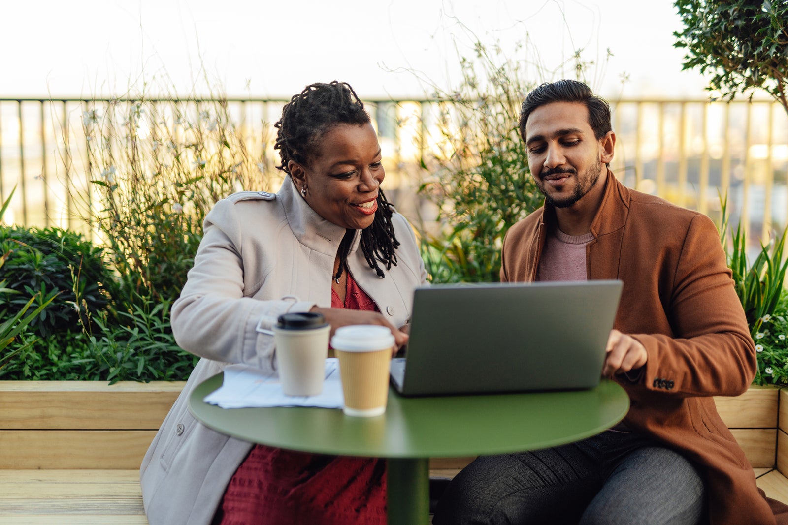 Two people at rooftop garden looking at computer Oscar Wong