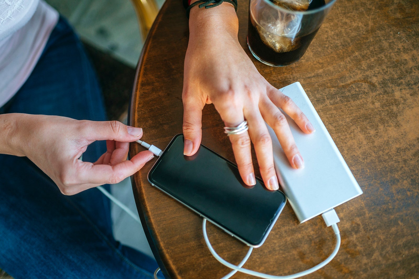 Close-up of Woman's hands plugging a mobile phone into a power bank