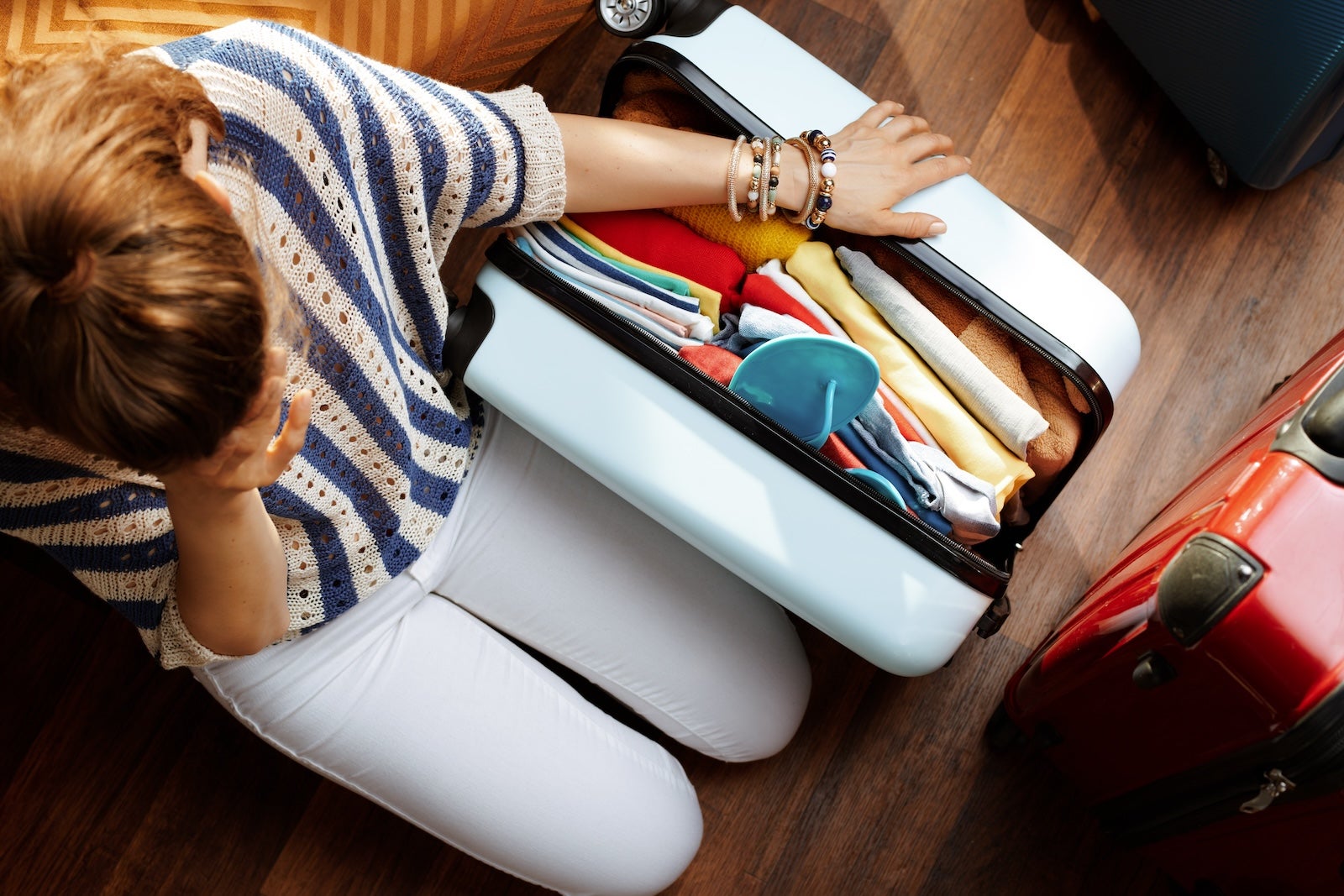 stressed elegant woman near over packed suitcase