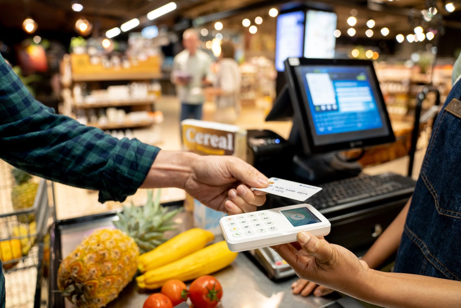 Close-up on a customer making a contactless payment at the supermarket