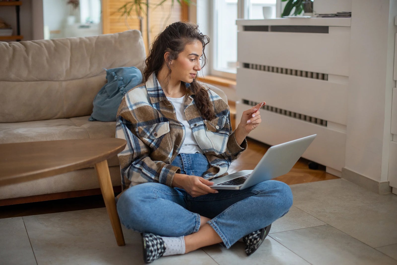 Woman using her credit card while on laptop at home Rockaa